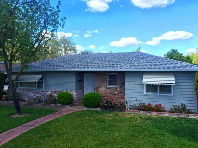 Blue-gray home with brick accents and a fresh slate-gray shingle roof